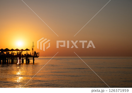 Beautiful sea view at sunrise, sunset. Silhouette of the pier. Rest at the sea, in the hotel, relaxation Beautiful sea view at sunrise, sunset. Silhouette of the pier. Rest at the sea, in the hotel, relaxation 126371959