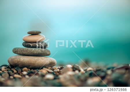 A pyramid of stones on a pebble beach by the sea, the concept of balance, calm, tranquility, relaxation with copy space A pyramid of stones on a pebble beach by the sea, the concept of balance, calm, tranquility, relaxation with copy space 126371986