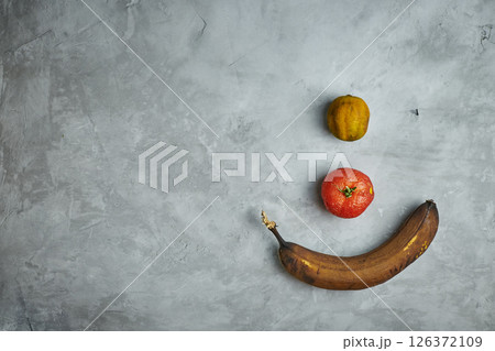 Ugly food. spoiled products lie on a gray concrete background. Ugly food. spoiled products lie on a gray concrete background. 126372109