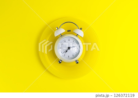 concept good morning alarm clock on a yellow plate 126372119