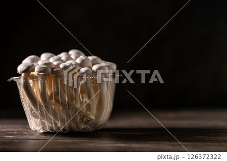 Closeup of a bunch of shimeji mushrooms on wooden board, with selective focus Closeup of a bunch of shimeji mushrooms on wooden board, with selective focus 126372322