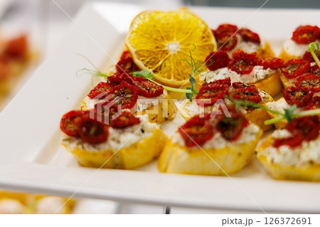 Delightful selection of gourmet bruschetta topped with sun-dried tomatoes and herbs awaiting tasting at an event 126372691