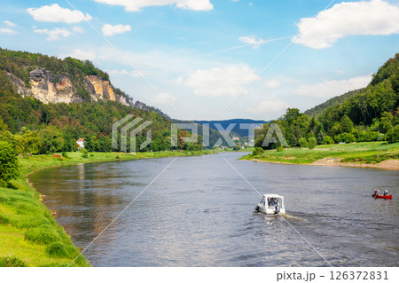 Panoramic scenic view rental boat cruising Elbe river curve Sachsische Schweiz National Park Germany Koenigstein Whelen mountain valley blue sky sunny day. Europe travel nature landscape destination Panoramic scenic view rental boat cruising Elbe river curve Sachsische Schweiz National Park Germany Koenigstein Whelen mountain valley blue sky sunny day. Europe travel nature landscape destination 126372831