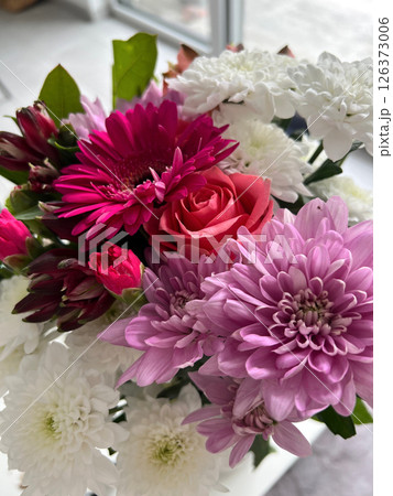 Vibrant bouquet of assorted flowers featuring pink gerbera daisies and delicate white chrysanthemums 126373006