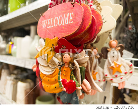 Colorful handmade welcome ornaments displayed in a charming store setting Colorful handmade welcome ornaments displayed in a charming store setting 126373716