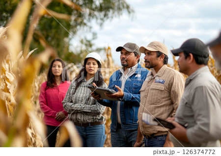 A diverse group of farmers inspecting smart farming technology in a field during autumn. Generated image A diverse group of farmers inspecting smart farming technology in a field during autumn. Generated image 126374772