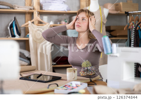 Tired dressmaker worker at table 126374844