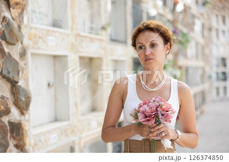 Upset woman remembers deceased relative at cemetery 126374850