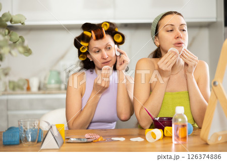 Two women cleanse their face with cotton pads 126374886