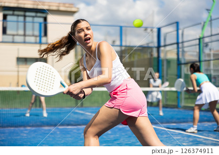 Woman on the court playing paddle tennis Woman on the court playing paddle tennis 126374911