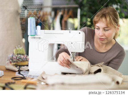 Woman tailor working at sewing machine 126375134
