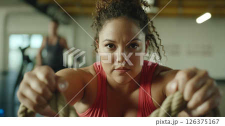 Plus size woman focused on training with battle ropes in the gym, showcasing strength and determination. Generated image 126375167