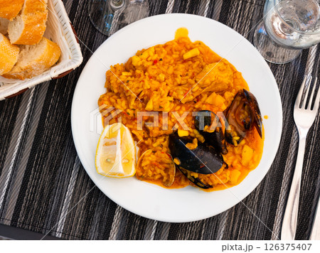 Valencian seafood paella - savory rice dish with shrimps, clams and chicken 126375407