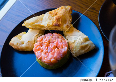 Salmon tartare with guacamole and toasts 126375432