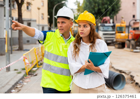 Master builder and architect talking in construction area Master builder and architect talking in construction area 126375461