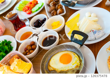 Turkish halal breakfast with cheeses, olives, bread, eggs, vegetables, walnuts 126375478