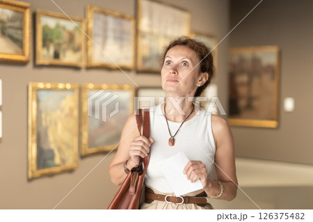 Woman viewing art gallery with brochure 126375482