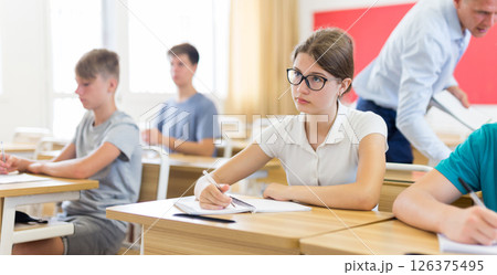 Portrait of positive teenage schoolgirl sitting on lesson 126375495