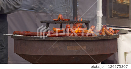 Hot Dogs and Sausages Grilling Over Open Flames on an Outdoor Barbecue Hot Dogs and Sausages Grilling Over Open Flames on an Outdoor Barbecue 126375807