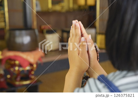 合掌をして故人を弔う子ども 126375821
