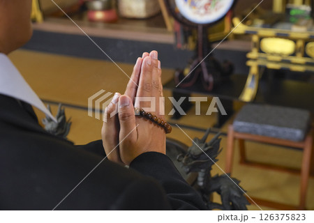 合掌をして故人を弔う遺族 126375823