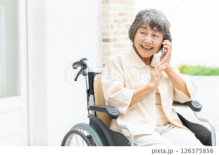 スマートフォンで通話する車椅子のシニア女性 126375856