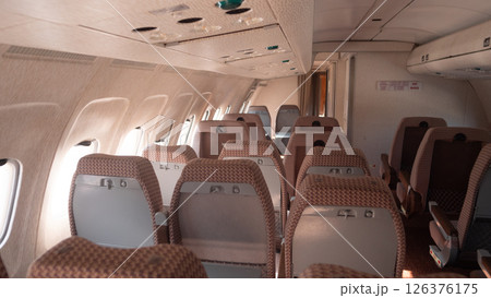 Inside a Soviet-era aircraft with vintage design, the cabin features empty rows of seating, illustrating the unique travel experience in Russia's aviation history. 126376175