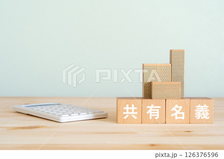 共有名義と書かれたブロック、電卓、不動産の模型 共有名義と書かれたブロック、電卓、不動産の模型 126376596