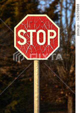Stop sign with broken paint peeling 126376668
