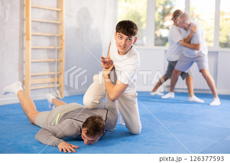 Two men training judo technique in studio Two men training judo technique in studio 126377593