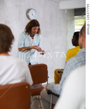 Man lecturing to group of men gathered in study hall Man lecturing to group of men gathered in study hall 126377795