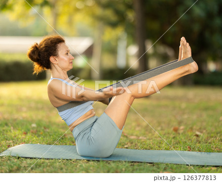 Adult woman doing yoga with strap Adult woman doing yoga with strap 126377813