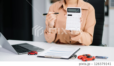 Asian people car salesman or sales manager offers to sell a car and explains of signing a car contract and signing car Asian people car salesman or sales manager offers to sell a car and explains of signing a car contract and signing car 126379141