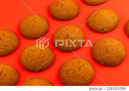 Freshly baked round cookies on vibrant red background Freshly baked round cookies on vibrant red background 126381094