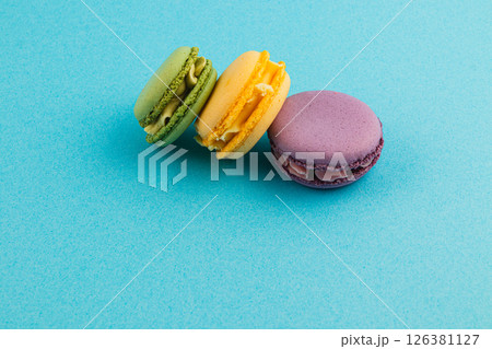 Colorful macarons arranged on blue background Colorful macarons arranged on blue background 126381127