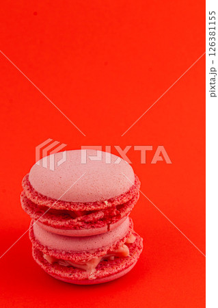 Delicious pink macarons stacked on a bright red background Delicious pink macarons stacked on a bright red background 126381155