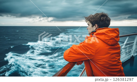 Man's sea journey, gazing at ocean wake, thoughtful journey into vastness. Journey 126381297