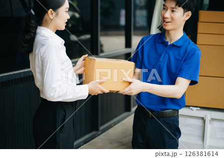 Express Delivery Service. Asian Courier Delivering Package to man Delivery service near van outside the warehouse, delivery home Express Delivery Service. Asian Courier Delivering Package to man Delivery service near van outside the warehouse, delivery home 126381614