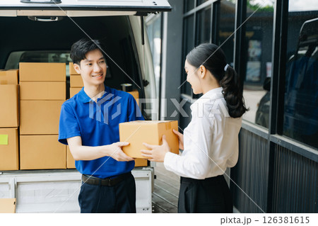 Express Delivery Service. Asian Courier Delivering Package to man Delivery service near van outside the warehouse, delivery home Express Delivery Service. Asian Courier Delivering Package to man Delivery service near van outside the warehouse, delivery home 126381615