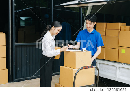 Express Delivery Service. Asian Courier Delivering Package to man Delivery service near van outside the warehouse, delivery home Express Delivery Service. Asian Courier Delivering Package to man Delivery service near van outside the warehouse, delivery home 126381621