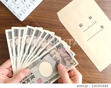 机上で紙幣を持つ女性の手元 126381689