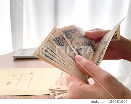 お金を数える女性の手元 お金を数える女性の手元 126381695