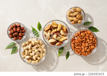 Different types of nuts in transparent glass bowls on a white background Different types of nuts in transparent glass bowls on a white background 126381815