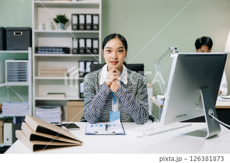 Young attractive Asian female office worker business suits smiling at camera with working 126381873