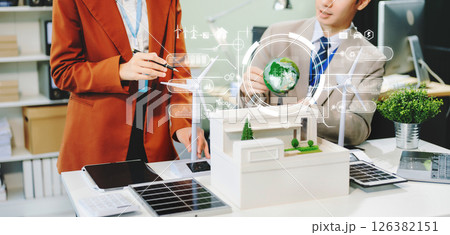 businesspeople standing neare table looking at model of building from residential project. Green business company and Solar Energy 126382151