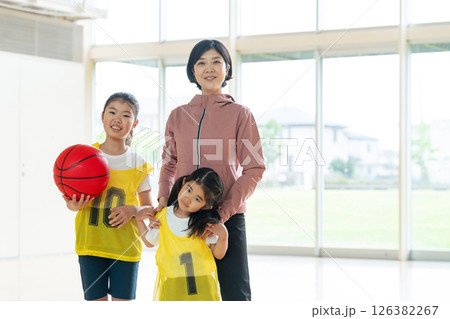バスケットボールをする子供たちと女性コーチ バスケットボールをする子供たちと女性コーチ 126382267