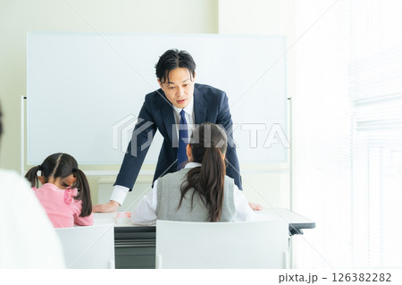 教室で子供たちに授業する男性教師 教室で子供たちに授業する男性教師 126382282