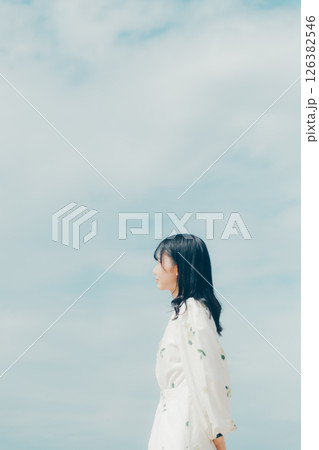 静かな海辺に佇む白い服の女性 126382546