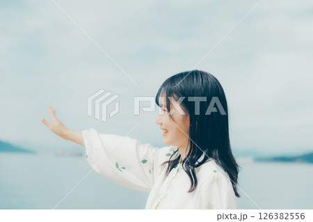 静かな海辺に佇む白い服の女性 126382556