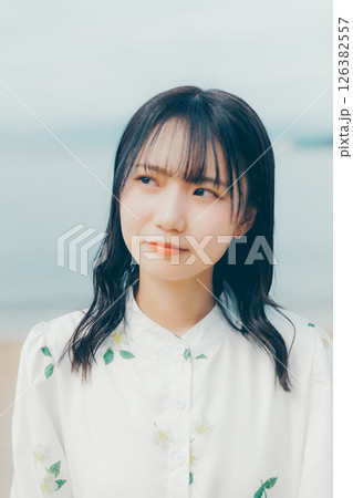 静かな海辺に佇む白い服の女性 126382557